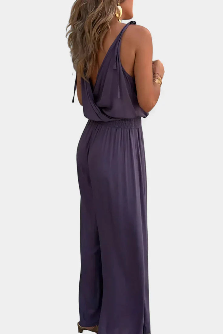 Macacão feminino com design elegante, decote cruzado, detalhes dourados e costas abertas, perfeito para verão chique.