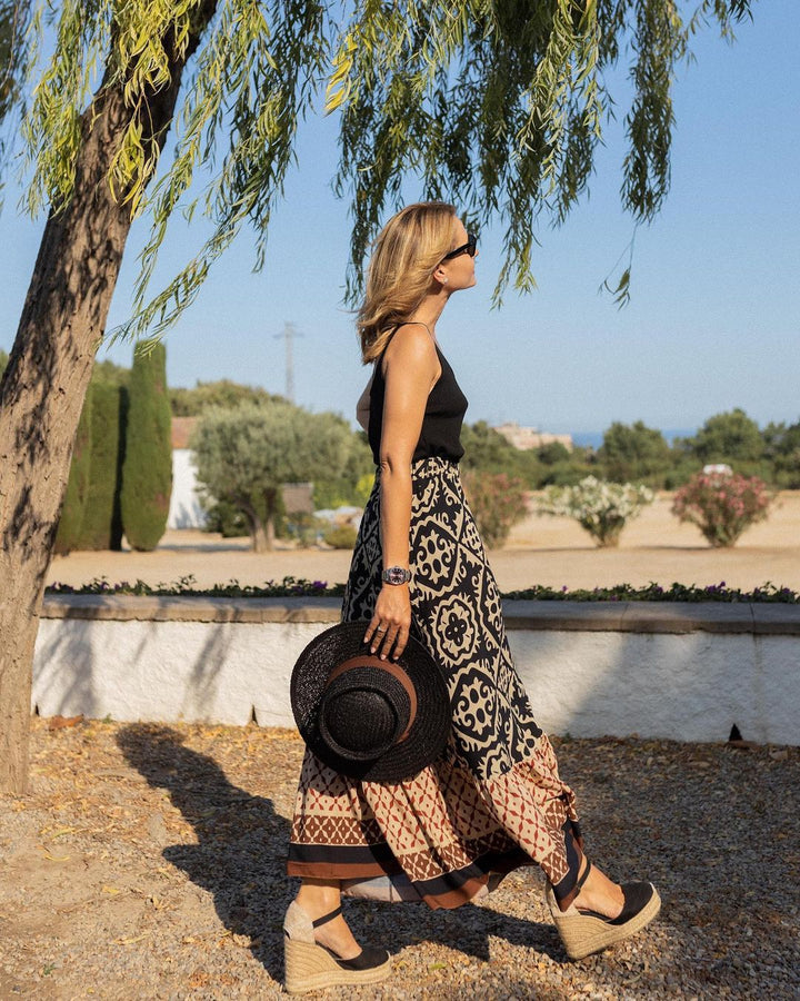 Saia estampada feminina com babados e cintura alta, estilo maxi boho vibrante para o verão. Conforto e elegância.