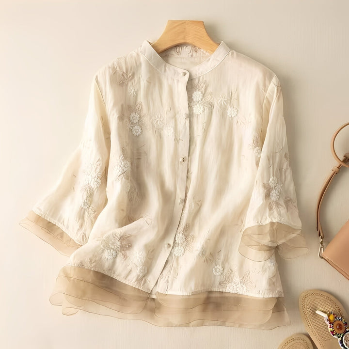 Blusa feminina leve com bordado floral vibrante. Peça versátil e elegante para um look casual ou profissional.