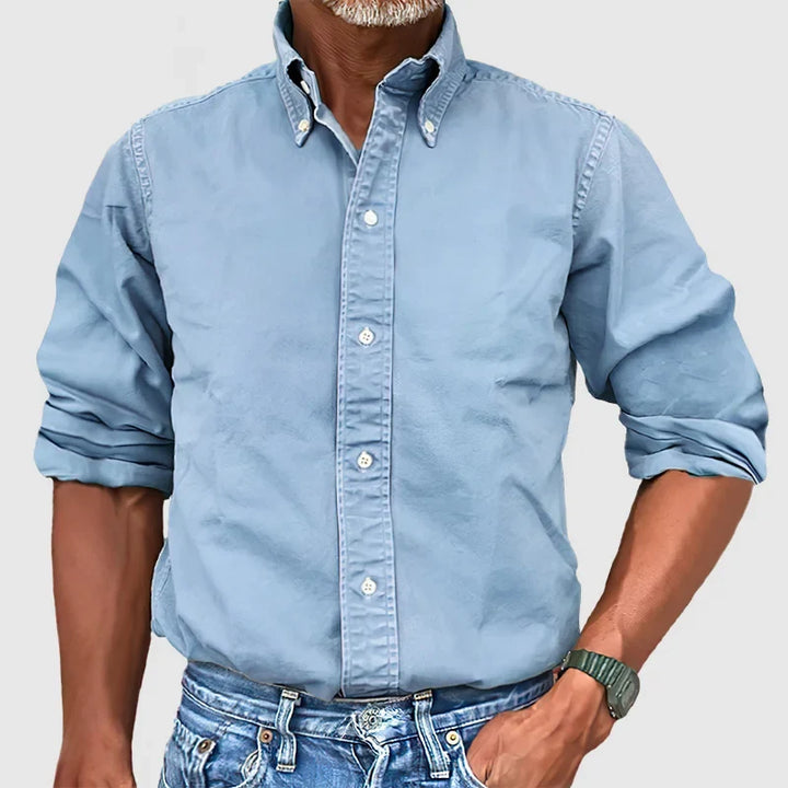 Close-up de camisa masculina vintage, mostrando tecido desgastado e detalhes autênticos.