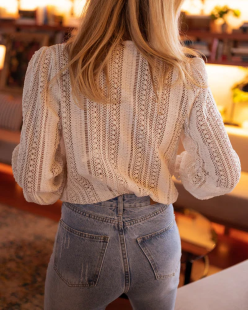 Moda verão: blusa feminina de crochê com decote V e manga bufante. Design elegante e boêmio, ideal para dias quentes.