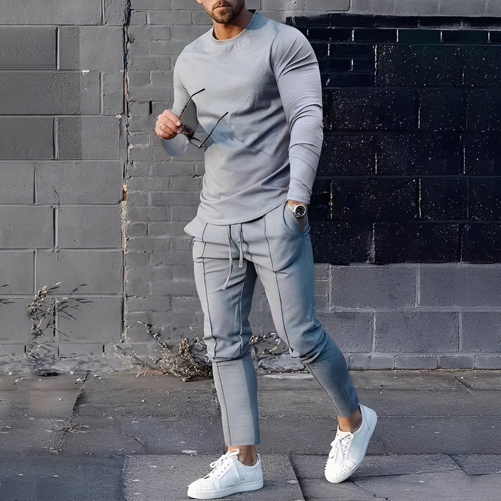 Homem vestindo conjunto casual de suéter e calça, ideal para relaxar ou atividades diárias. Moda masculina.