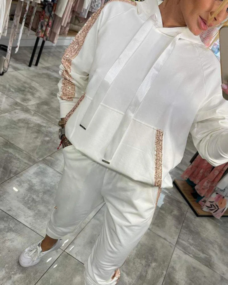 Conjunto feminino Lina de duas peças: calça flare confortável e blusa de moletom com lantejoulas. Versatilidade.