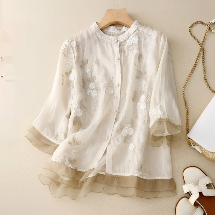 Blusa feminina bordada com flores delicadas, ideal para o verão, primavera ou escritório. Elegância casual e confortável.