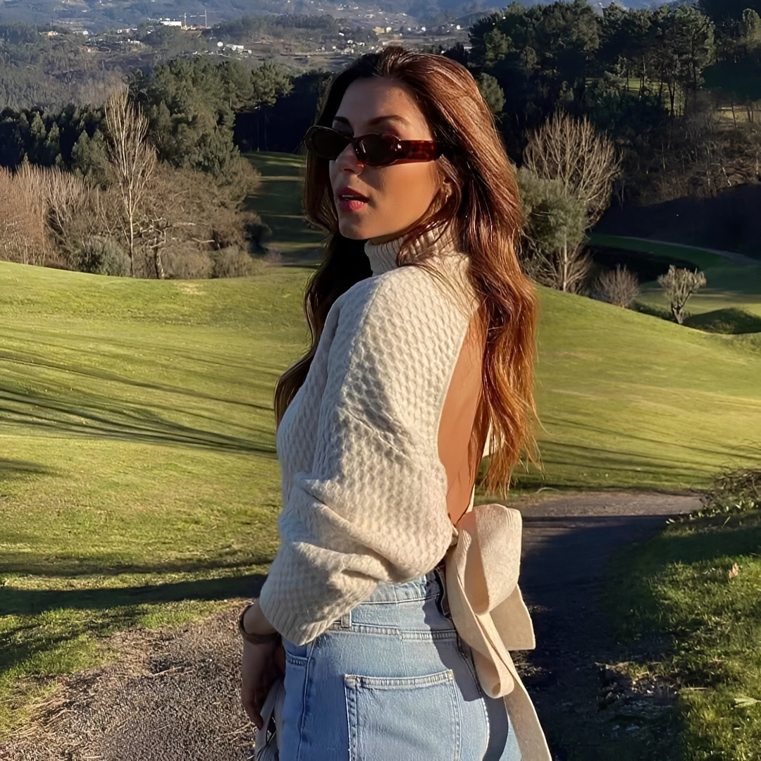 Suéter feminino bege elegante com laço nas costas, perfeito para looks de inverno e casual chic.