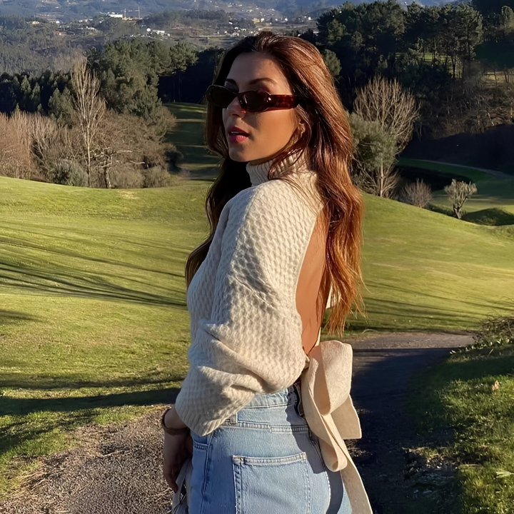 Suéter feminino bege elegante com laço nas costas, perfeito para looks de inverno e casual chic.