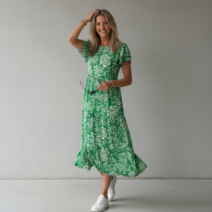Modelo veste vestido midi feminino estampado com caimento fluido, perfeito para um look casual de verão.