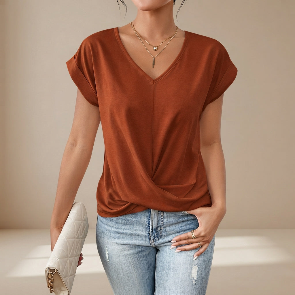 Modelo de camiseta feminina leve, decote V, detalhe torcido, disponível em cores diversas para o verão.
