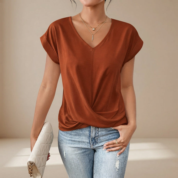 Modelo de camiseta feminina leve, decote V, detalhe torcido, disponível em cores diversas para o verão.