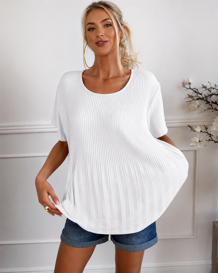 Mulher veste blusa plissada feminina em cor vibrante. Estilo elegante e confortável, perfeita para ocasiões de verão.