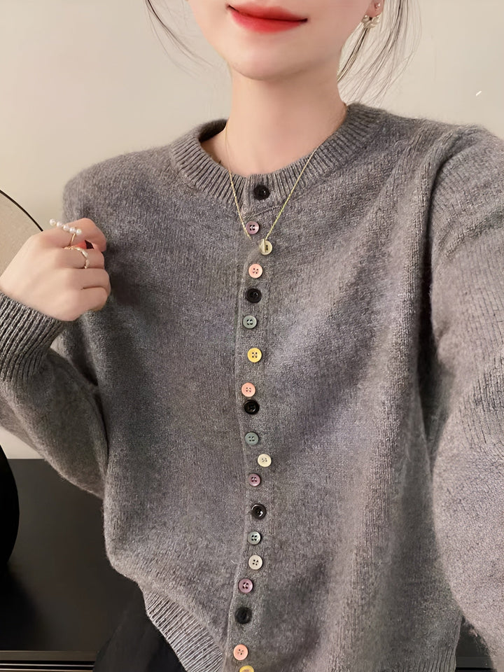 Colete feminino Nora de malha com botões. Peça essencial para outono/inverno, oferece conforto e estilo versátil.