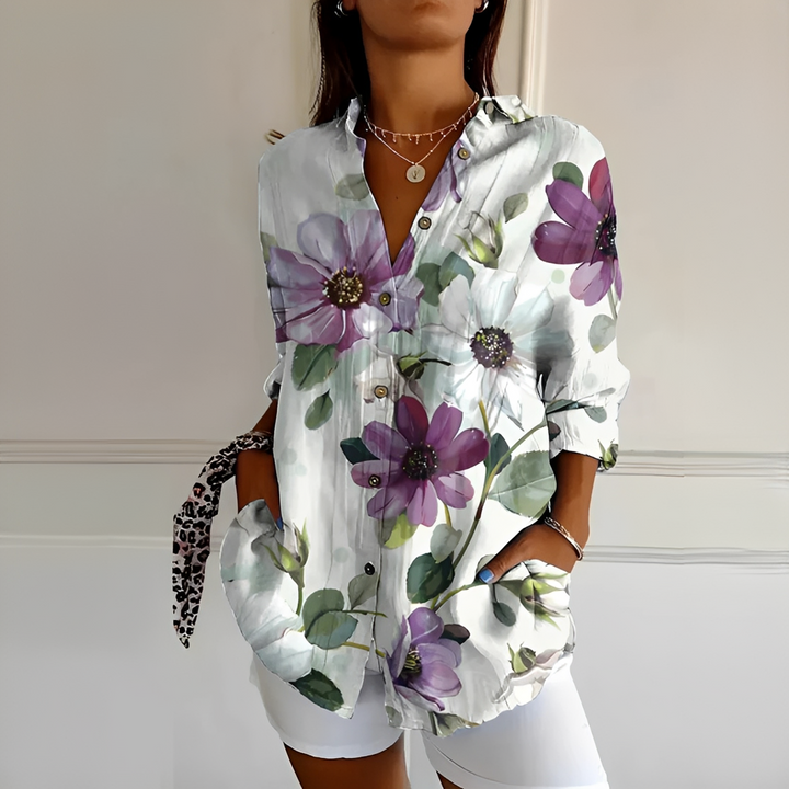 Detalhe da blusa feminina Eleanor floral vibrante com botões frontais, moda elegante e versátil.