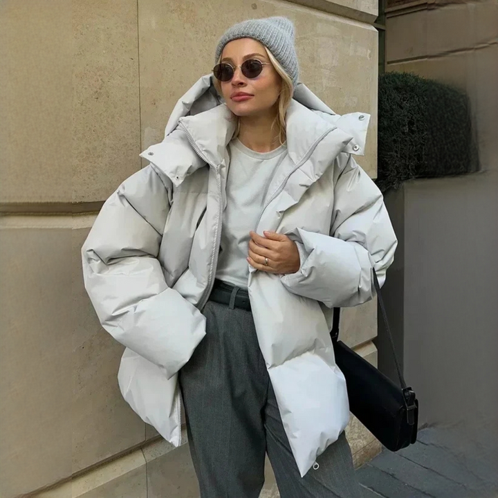 Casaco feminino de inverno acolchoado, com capuz, proporcionando conforto térmico. Perfeito para dias frios.