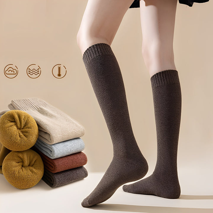Par de meias overknee femininas em tom neutro, oferecendo conforto e moda para os dias frios de inverno.