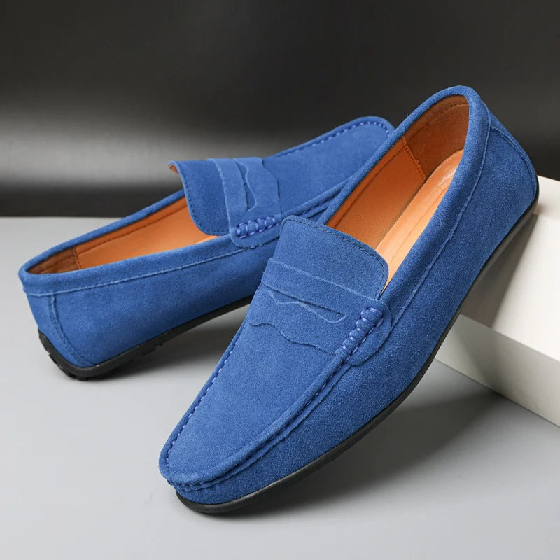 Mocassim masculino elegante em camurça azul-marinho, perfeito para calçado casual e confortável nas estações quentes.