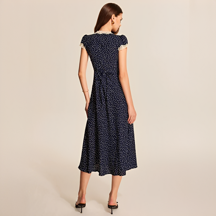 Vestido feminino de verão azul marinho, elegante com aplicação de renda e estampa de bolinhas. Look versátil.