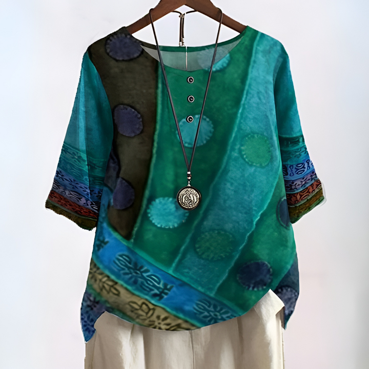 Camisa feminina boho com mangas três quartos, decote nó e estampa artística de cores vibrantes. Moda verão.