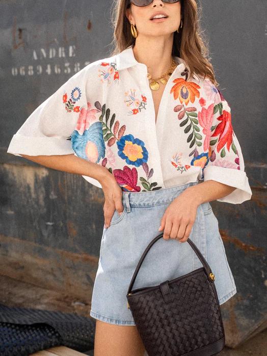 Roupa feminina: camisa casual de manga curta com padrão floral alegre. Estilo vibrante para dias quentes.
