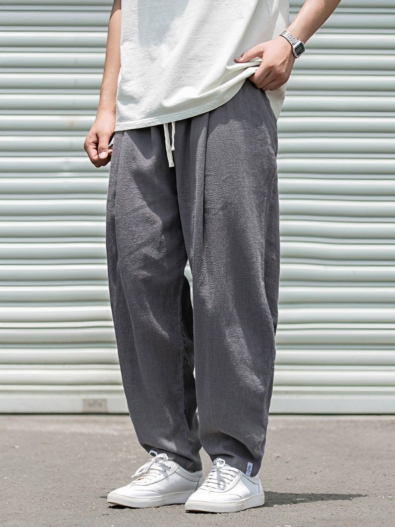 Homem veste calça masculina reta larga, look confortável para o verão. Roupa solta de dia a dia com estilo casual e fresco.