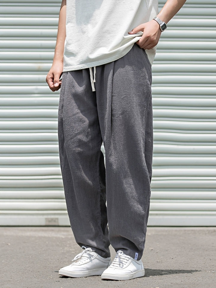 Homem veste calça masculina reta larga, look confortável para o verão. Roupa solta de dia a dia com estilo casual e fresco.