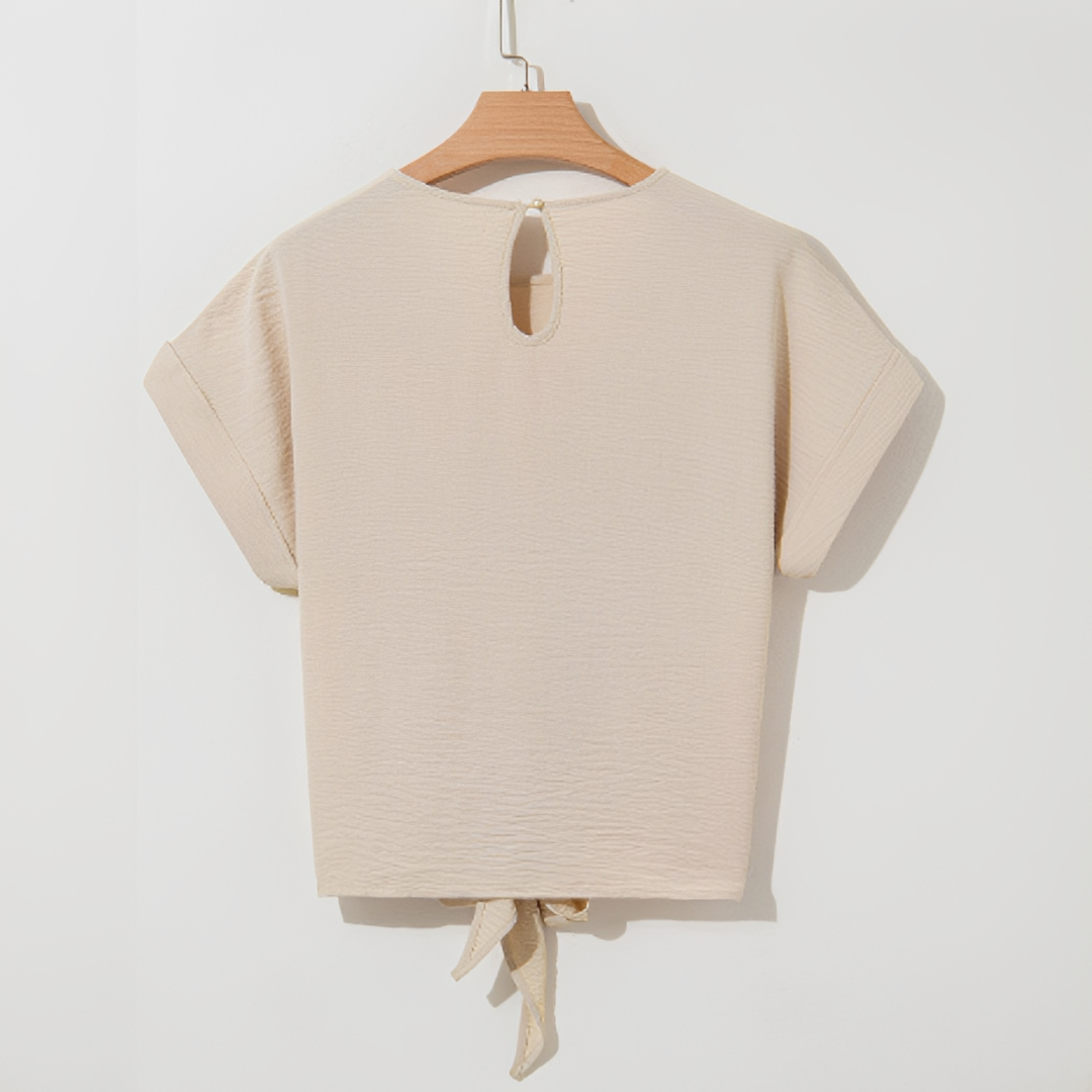 Look casual de verão com blusa feminina bege de manga curta. Peça versátil para conforto e estilo diário.