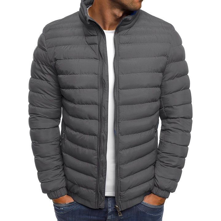 Modelo vestindo jaqueta masculina acolchoada preta, ideal para o inverno. Look casual e moderno para roupa masculina.