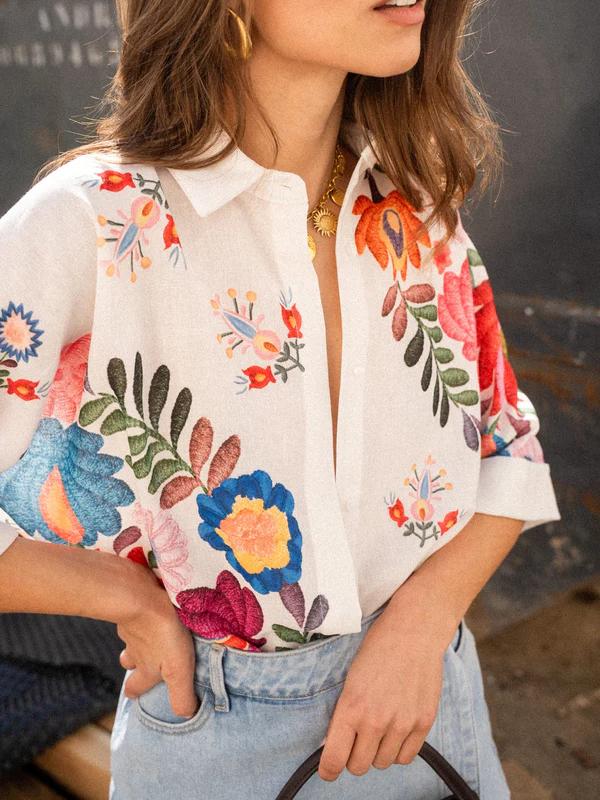 Detalhe da camisa feminina: estampa floral vibrante e tecido leve. Ideal para looks de verão e boêmios.