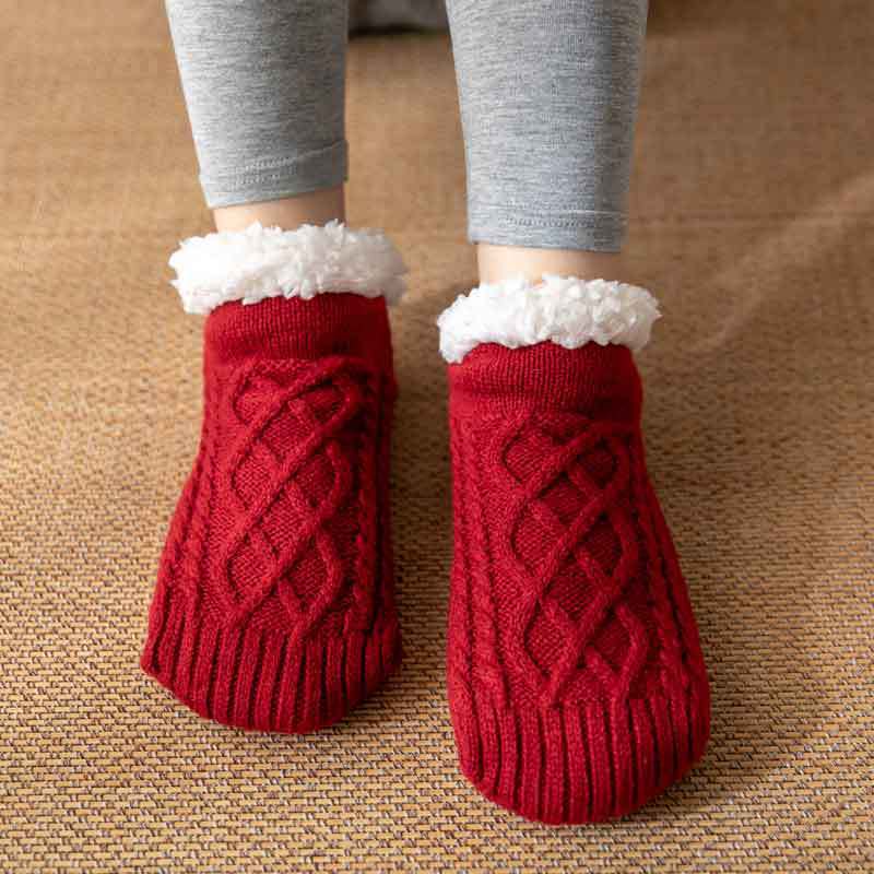 Mulher usando meias femininas quentes com solado antiderrapante. Ideal para caminhar pela casa com segurança no inverno.