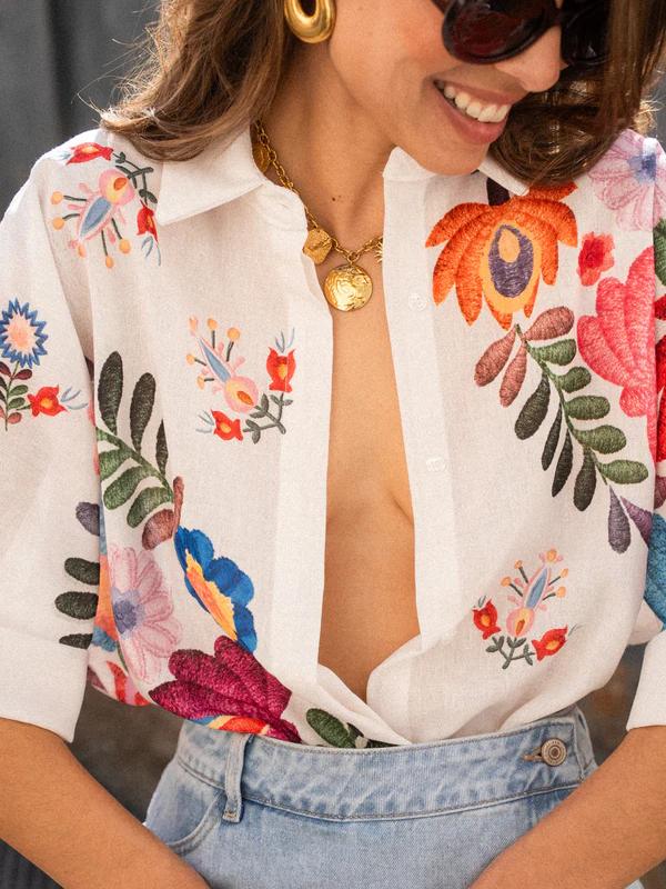 Modelo usando camisa feminina de manga curta com estampa floral, perfeita para um dia de verão.