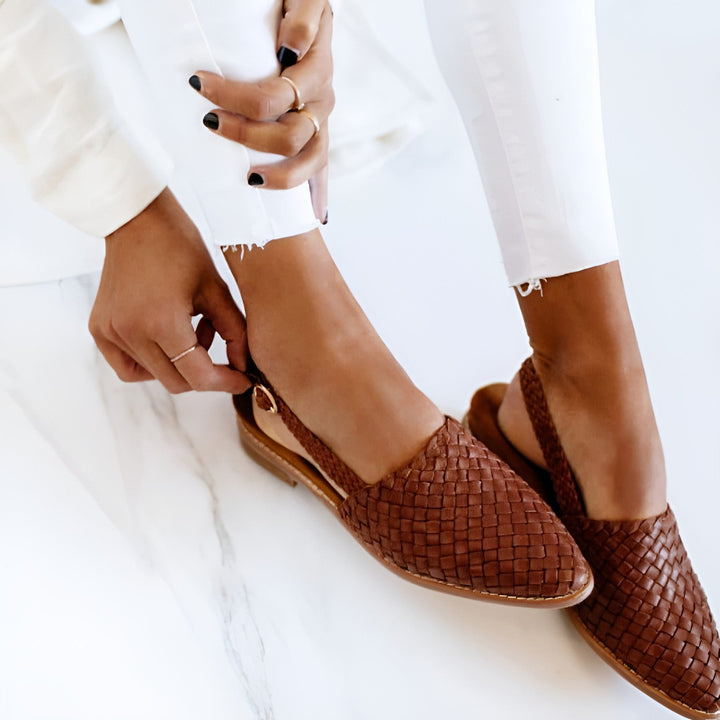 Pés em sandálias trançadas femininas, demonstrando conforto para um calçado de verão casual. Sapatos de mulher ideais.