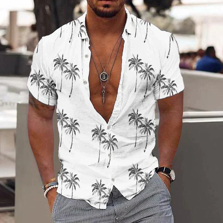 Homem vestindo camisa masculina tropical de verão, com estampa Brisa da Palmeira, leve e confortável.