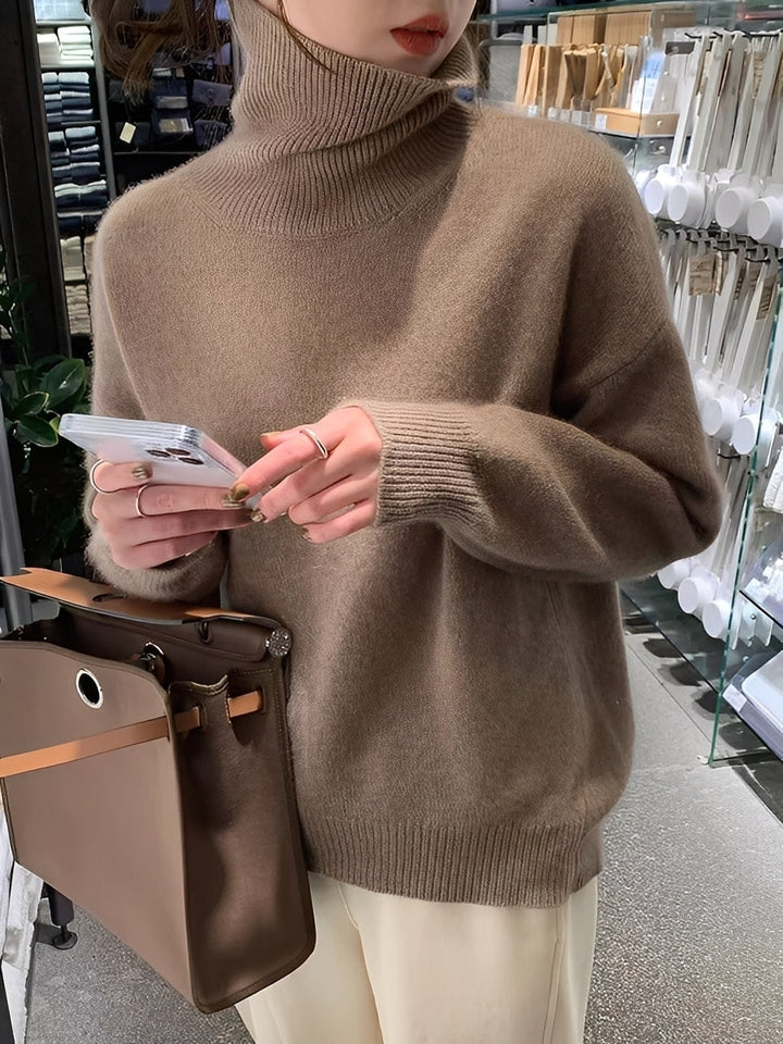 Suéter feminino de malha fina, gola alta e caimento solto. Essencial para moda feminina elegante e aconchegante.