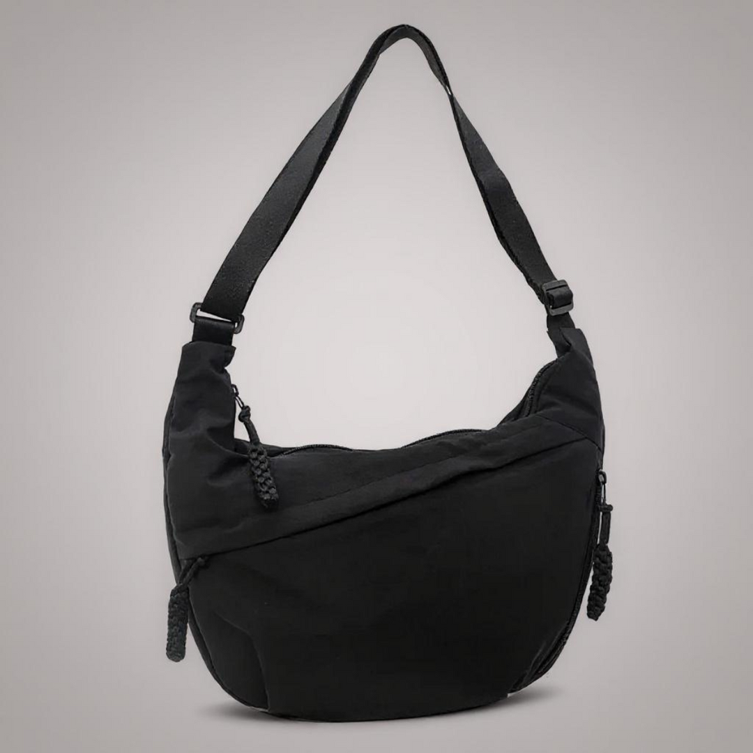 Bolsa feminina transversal antifurto preta, com múltiplos compartimentos e zíperes para segurança e organização em viagem.