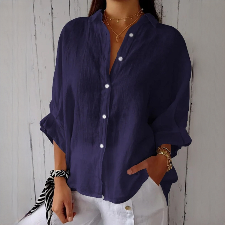 Mulher vestindo camisa feminina Reena casual. Blusa de manga comprida, confortável e estilosa para a moda do dia a dia.