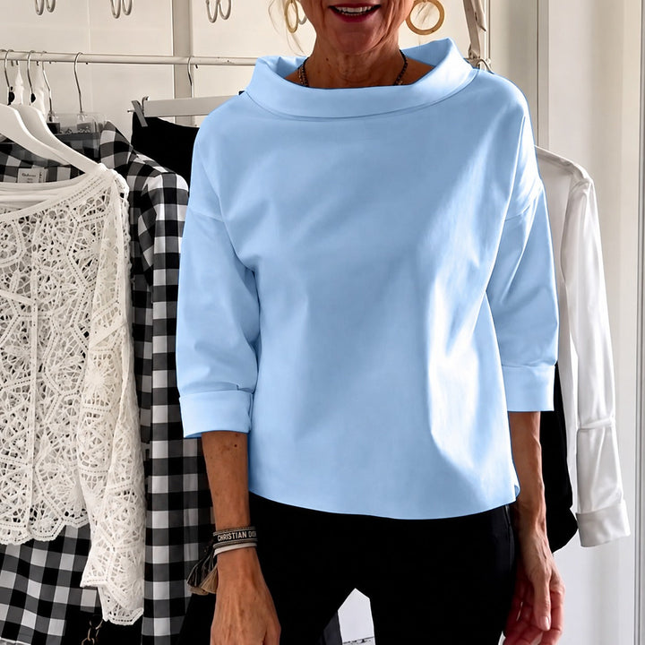 Top feminino elegante de gola alta, perfeito para visuais sofisticados. Moda versátil para trabalho e eventos.