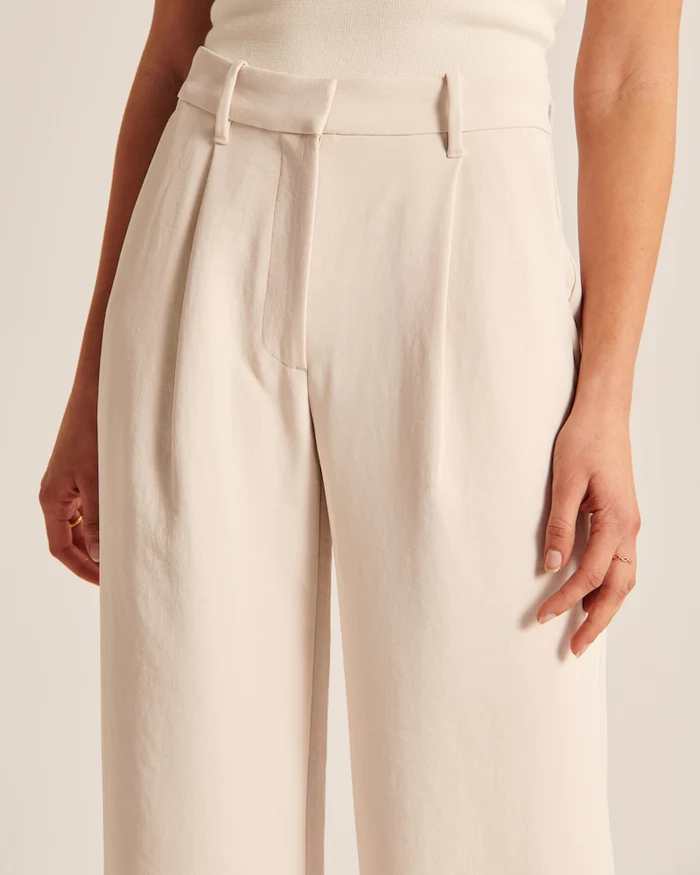 Calça feminina bege de alfaiataria sob medida, perna larga. Elegância e conforto em uma só peça.