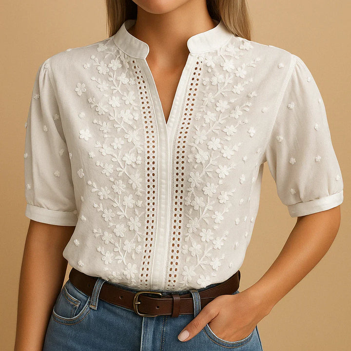 Blusa feminina Cambria elegante, branca, com bordado na gola fenda e mangas bufantes, perfeita para primavera.