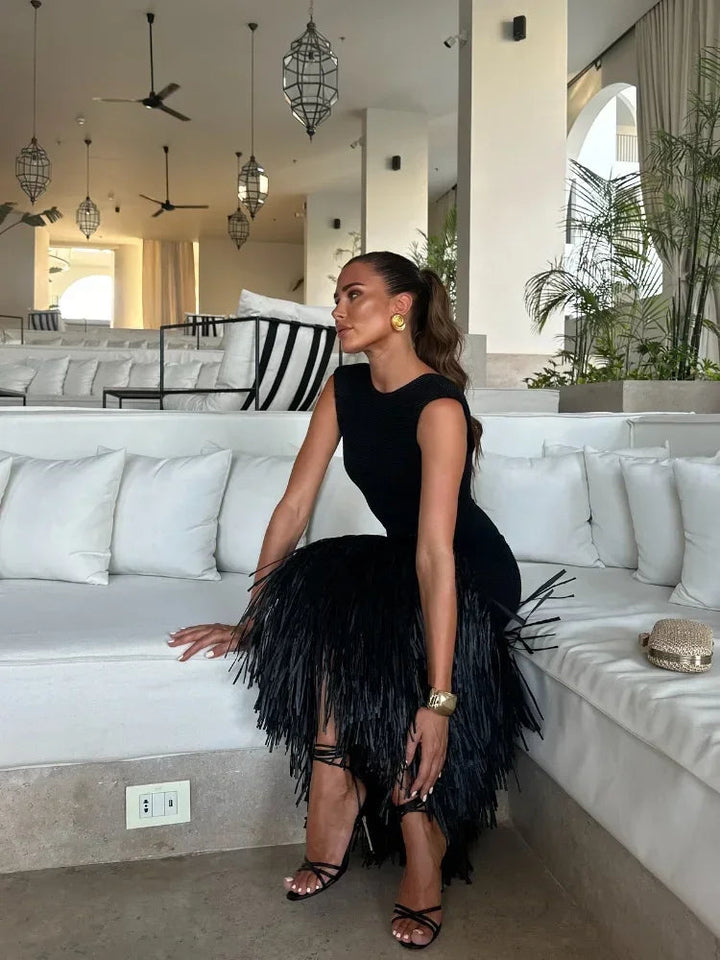 Vestido longo feminino com caimento elegante e detalhe de franjas, perfeito para eventos de gala.