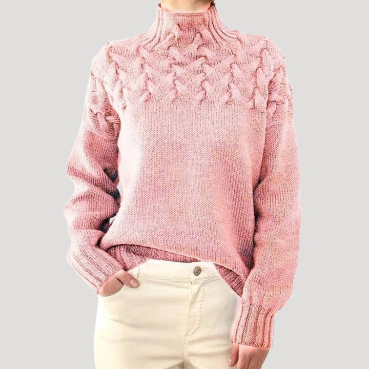 Detalhe de camisola de malha com padrão de tranças e gola alta, perfeita para o frio do outono inverno.
