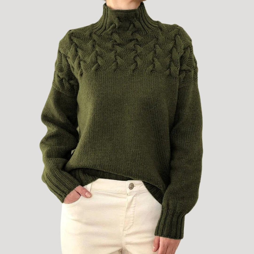 Padrão de tranças detalhado numa camisola de malha feminina de gola alta, sinónimo de estilo e qualidade.
