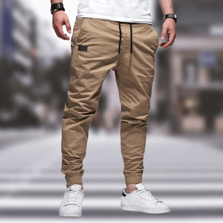 Calças cargo masculinas estilo streetwear, com bolsos laterais funcionais e cintura elástica, perfeitas para look urbano.