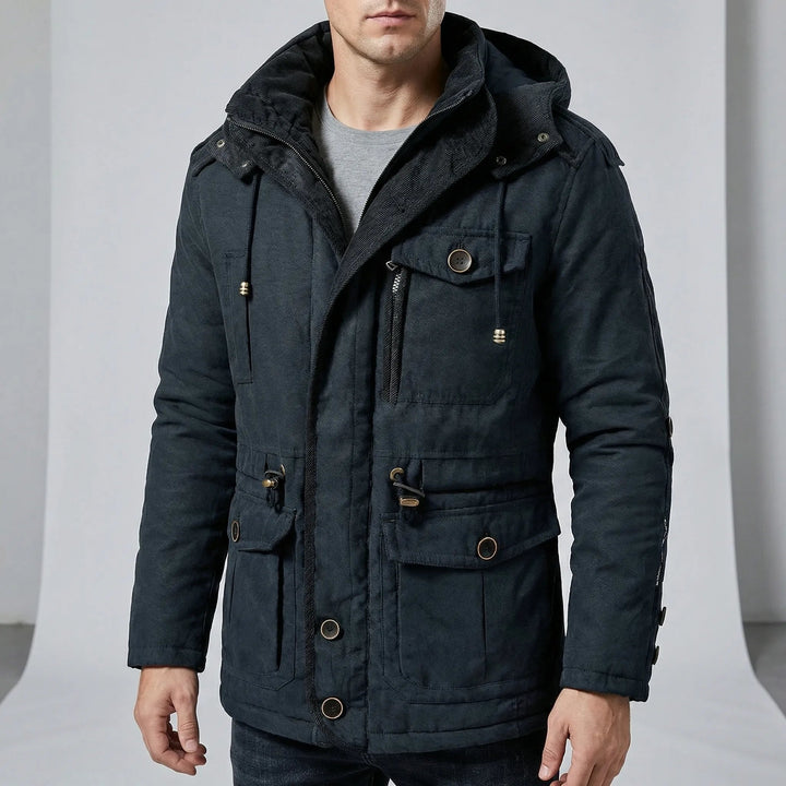 Homem usando parka masculina preta para inverno, com capuz e bolsos, estilo agasalho casual.