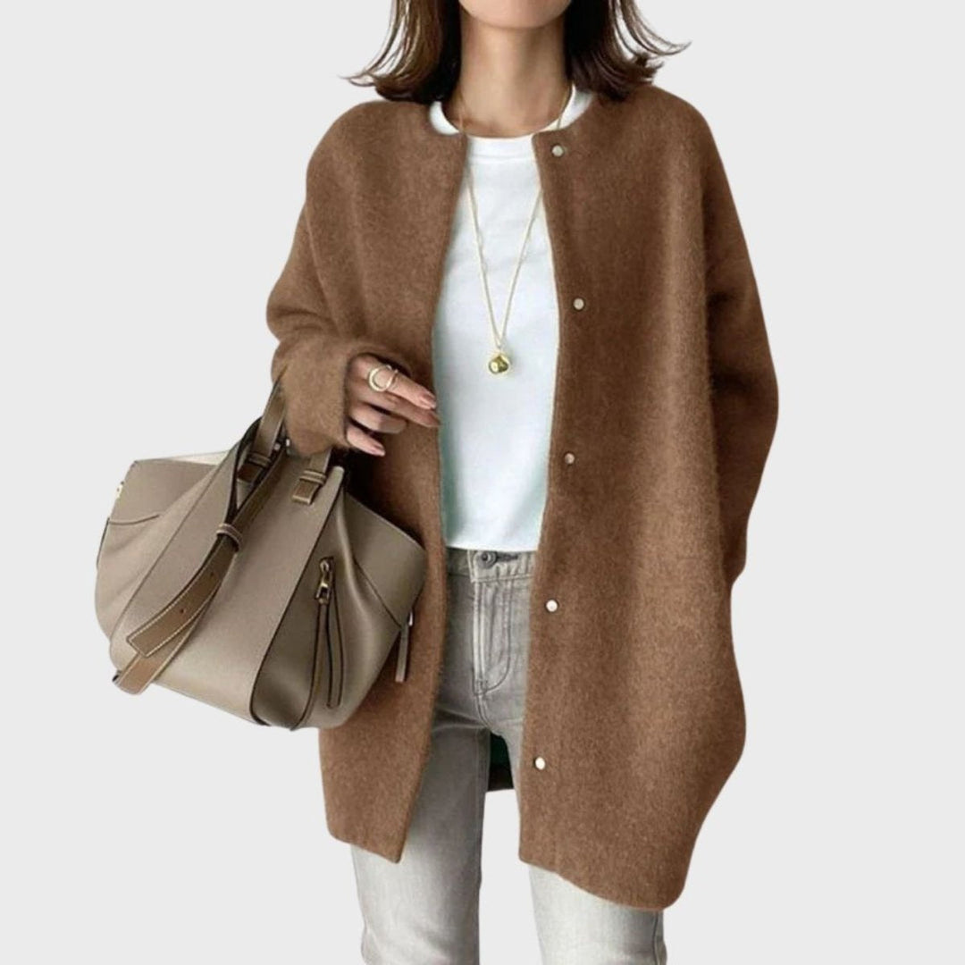 Detalhe dos botões de pressão num casaco de malha oversized feminino, realçando o conforto e estilo.