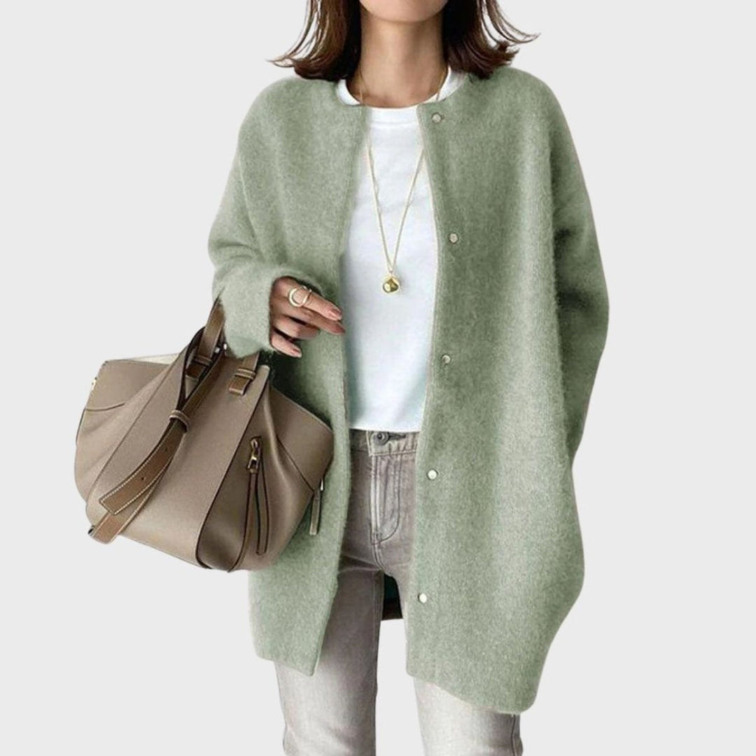 Modelo a sorrir, vestindo casaco de malha oversized feminino com botões, mostrando estilo e versatilidade.
