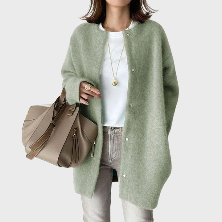 Modelo a sorrir, vestindo casaco de malha oversized feminino com botões, mostrando estilo e versatilidade.