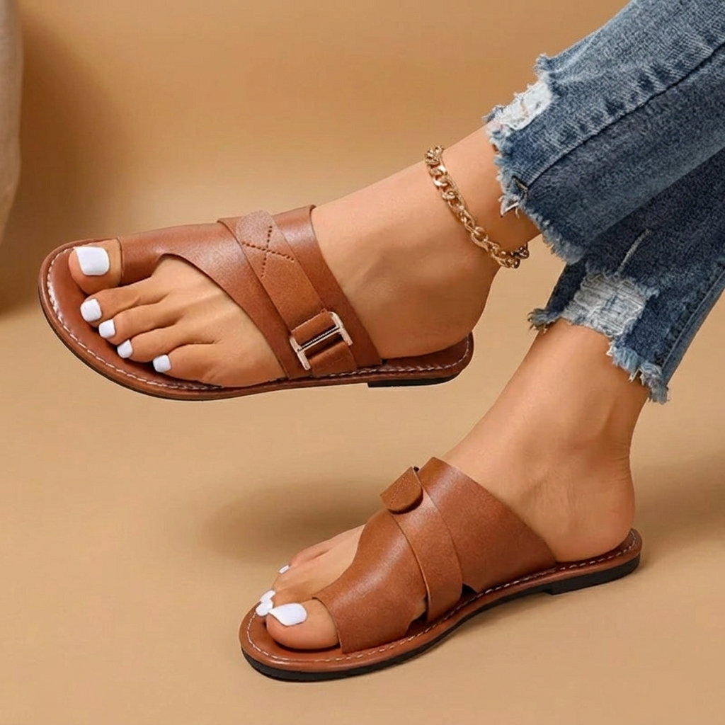 Detalhe das tiras cruzadas das sandálias rasas Cristina para mulher, sinónimo de estilo, conforto e casualidade.