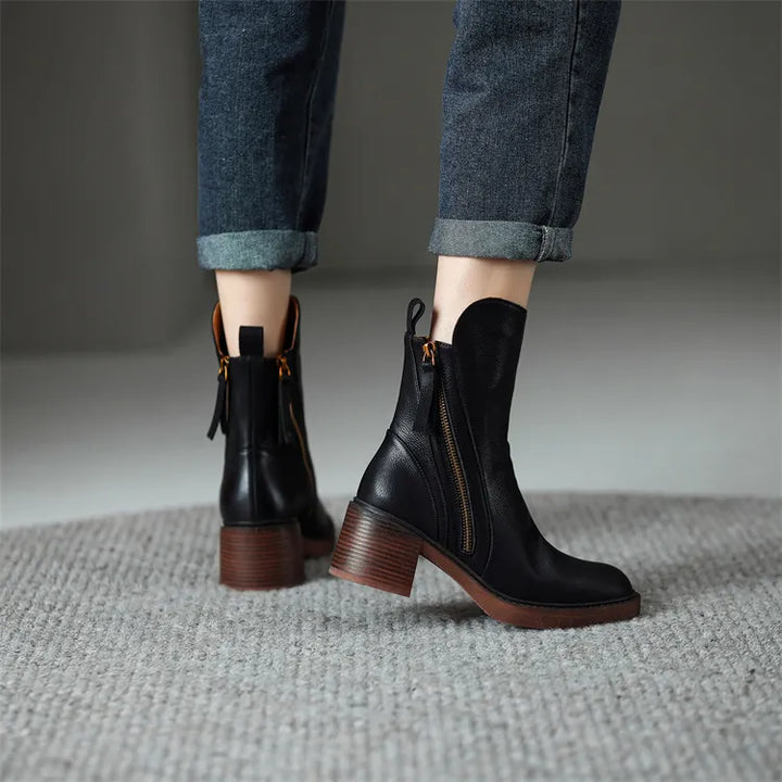 Par de botas femininas pretas de cano médio, design moderno, conforto para longas horas.
