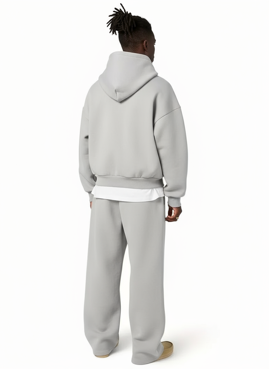 Homem veste conjunto treino com hoodie capuz e calças perna larga pretas, ideal para um look urbano e descontraído.