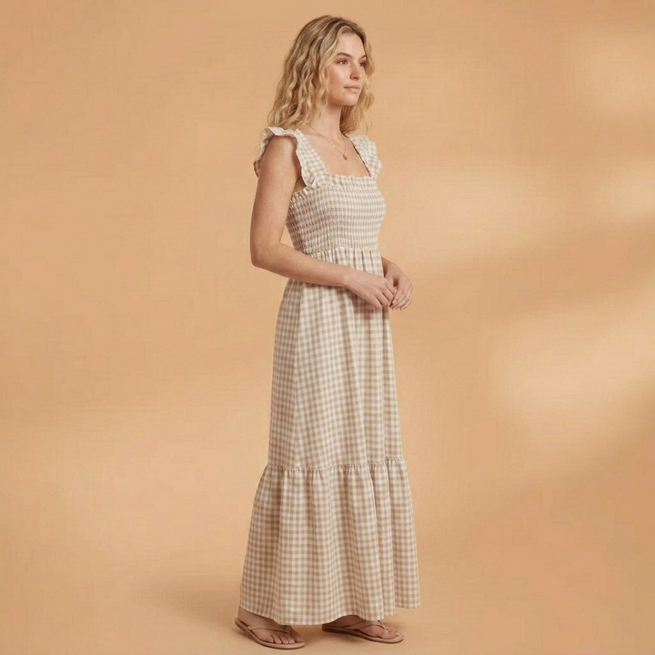 Vestido comprido de mulher em padrão xadrez, com alças de folhos. Oferece estilo e conforto no verão.