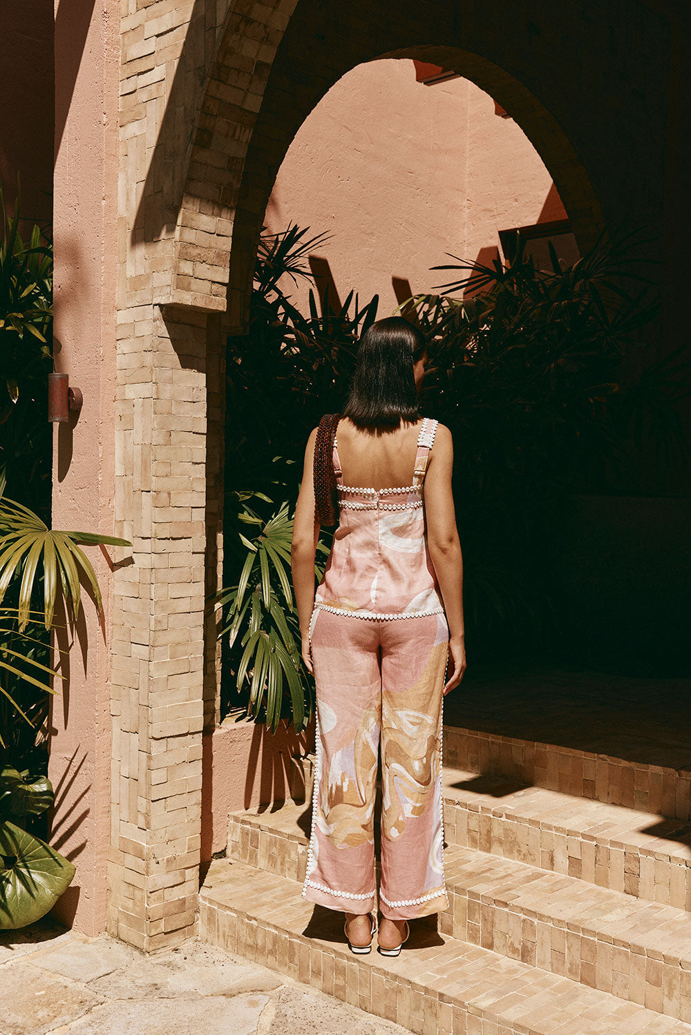 Look completo com blusa feminina rosa, estampa exclusiva, sem mangas. Peça elegante para o verão.